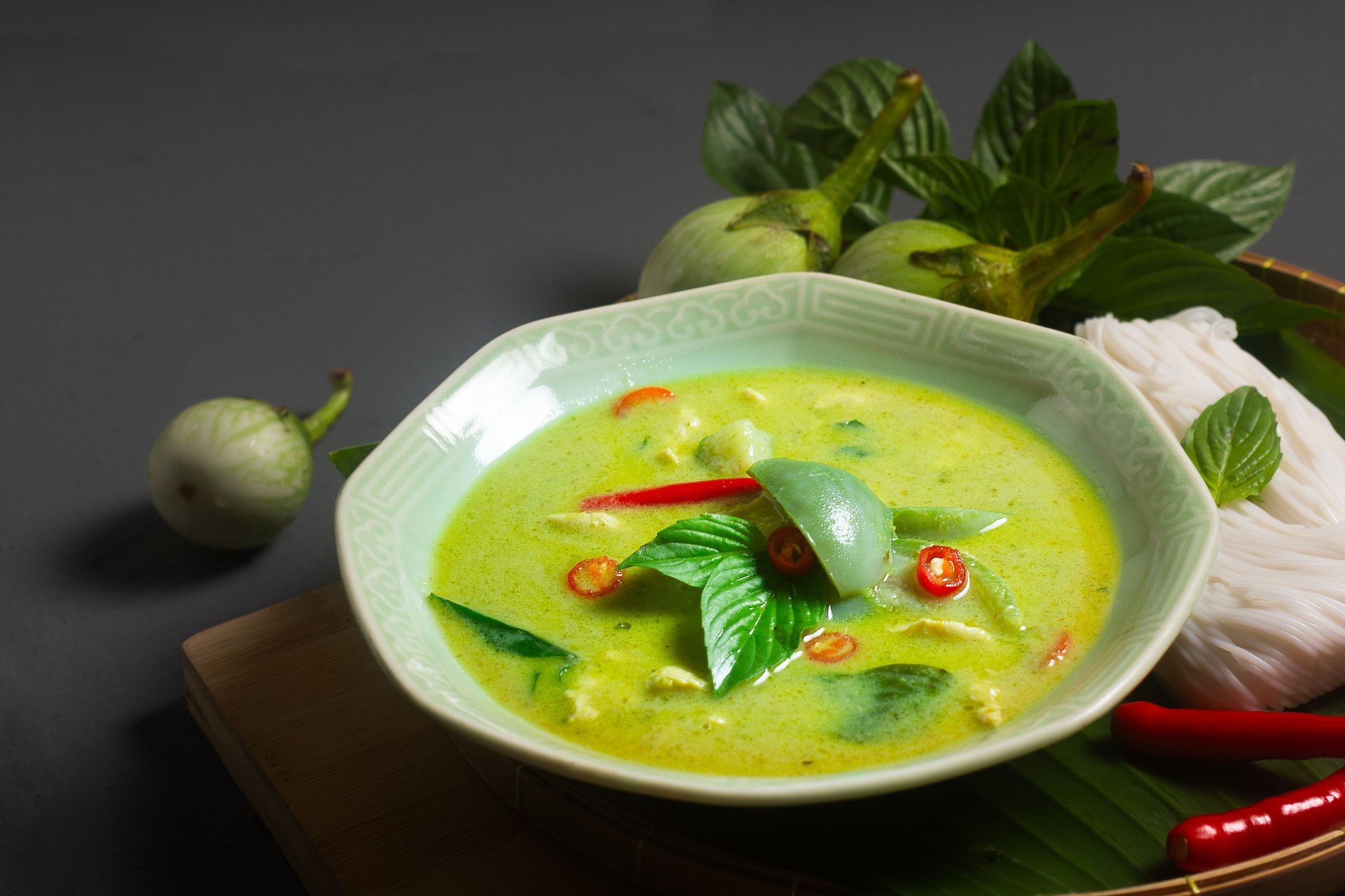 Asian Food concept Authentic Thai chicken Green Curry and thai green eggplant on wooden board with copy space